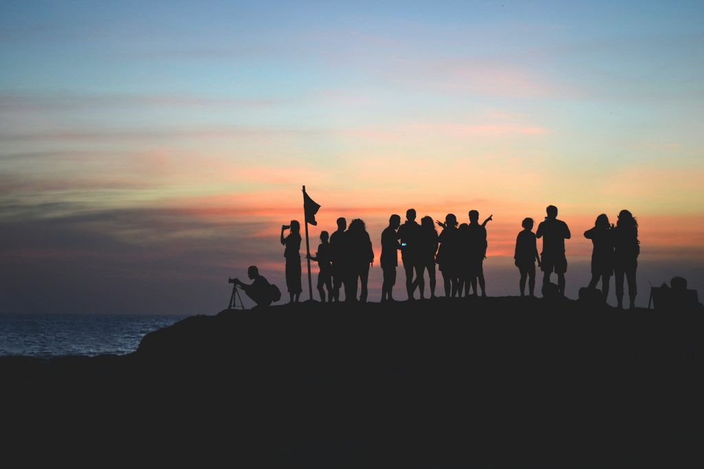 people on a cliff with sunset